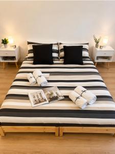 a large bed with black and white striped sheets and pillows at Near Airport Malpensa Pvt Room with Pvt Bath and Kitchen Check-in 24h in Legnano