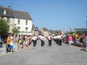 a large group of people walking down a street at Meublé centre-ville proche mer in Saint-Pol-de-Léon