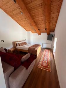 a bedroom with a bed and a couch and a television at Gurra resort in Klos