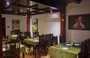 a dining room with tables and chairs with green table cloth at Suryamangalam Heritage in Cheruppulasseri