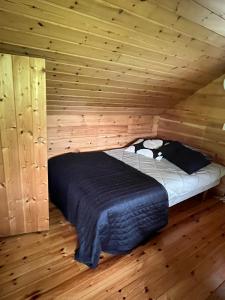 a bed in a wooden room in a log cabin at Private Riverside Cabin, Utajärvi in Korhola