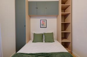 a small bedroom with a bed with green pillows at Viktor 3 - Hyper Centre - Place Jean Jaurès in Tours