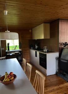 a kitchen with a table with a bowl of fruit on it at Private Riverside Cabin, Utajärvi in Korhola
