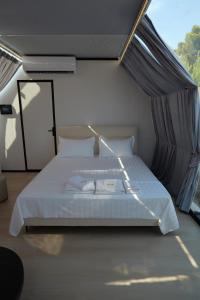 a bedroom with a white bed with a window at Piccolo Paradiso - Glamping Resort in Shëngjin +25 photos