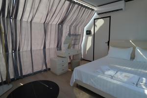 a bedroom with a bed and a desk and a mirror at Piccolo Paradiso - Glamping Resort in Shëngjin