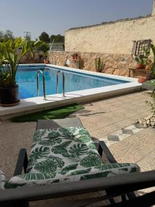 a chair with a cushion sitting next to a swimming pool at Casa Ana in Monóvar