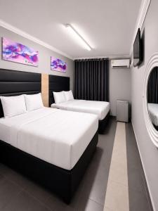 a hotel room with two beds and a tv at Metro Lodge MP in Durban