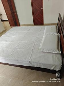 a bed with white sheets on it in a bedroom at Coco Kudil - FARM STAY in Salem
