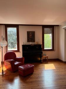 a living room with a piano and a chair at Storico appartamento con parco in Sanguinetto