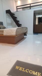 a welcome mat on the floor of a room with a bed at Raya Inn in Pandharpur
