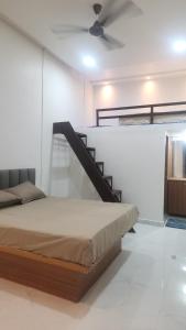 a bedroom with a bed and a staircase in a room at Raya Inn in Pandharpur