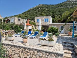 a patio with chairs and plants on a stone wall at Villa sea oasis Ratac in Slano