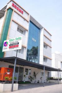 a building with a sign in front of it at Misty Suite Infopark in Cochin