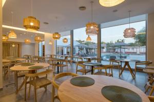 a restaurant with tables and chairs and a pool at VILLA BRANDA - Tavira Nature Hotel in Tavira