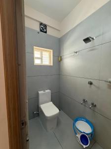 a small bathroom with a toilet and a window at Misty Suite Infopark in Cochin +16 photos