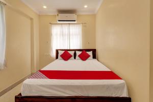 a bedroom with a bed with red pillows at Hotel O RD CONVENTIONS in Visakhapatnam +23 photos