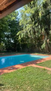 a blue swimming pool in a yard with trees at Storico appartamento con parco in Sanguinetto
