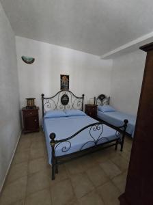 a bedroom with two beds with blue sheets at Villa Patrizia in Taviano