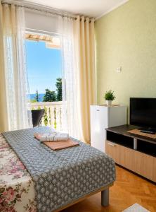 a bedroom with a bed and a television and a window at Tina Rooms in Ulcinj