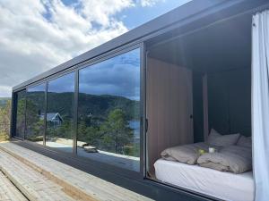 a bedroom with large windows and a bed on a balcony at Brennvika Panorama in Hamarøya