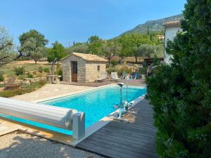 a swimming pool next to a house at LA BAPTISTINE FACE AU VENTOUX la Clue in Plaisians