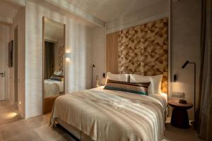 a bedroom with a large bed and a mirror at Meros, Santikos Collection in Naousa
