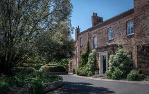 ein altes Backsteinhaus mit einer Einfahrt in der Unterkunft Stanbrook Abbey Hotel, Worcester in Worcester