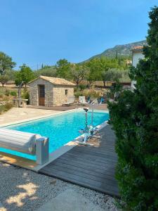 a pool with a wooden deck next to a house at Chambre d'hôtes une fenêtre sur le Ventoux in Plaisians