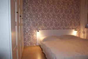 a bedroom with a bed and a wall with floral wallpaper at Nautilus 107 in Świnoujście