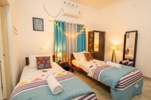 a bedroom with two beds and a mirror at VILLA MANTRAA in Varkala +86 photos