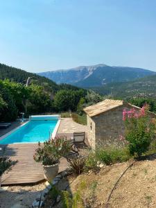 a villa with a swimming pool and mountains in the background at Chambre d'hôtes une fenêtre sur le Ventoux in Plaisians