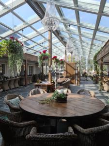 a conservatory with a table and chairs and a chandelier at Hotell & Spa Lögnäs Gård in Laholm