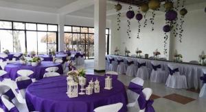 a banquet hall with purple and white tables and chairs at AGM Beachfront Resort in Donsol