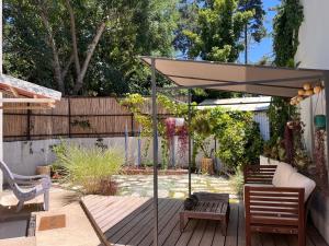 a patio with an umbrella on a wooden deck at Galilee Nook in Kefar Weradim