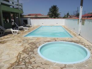 a large blue swimming pool on a stone patio at Pousada Canto da Ilha in Ilha Comprida