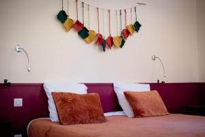 a bed with two pillows and a heart made of yarn at Chambres à la Table du Curé in Cucugnan