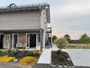 ein Gebäude mit einer Treppe und einer Bank in einem Hof in der Unterkunft Homemade Studio in Liebshausen