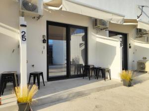 a patio with black chairs and tables outside of a building at CORFU INDUSTRIAL Studios in Corfu +58 photos