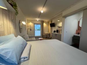 ein Schlafzimmer mit einem großen weißen Bett und eine Küche in der Unterkunft Homemade Studio in Liebshausen