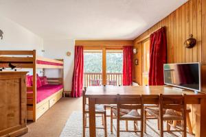 a bedroom with a dining room table and a bed at Large Méribel Three Valleys in Les Allues