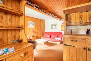 a living room with a red couch in a room at Large Méribel Three Valleys in Les Allues