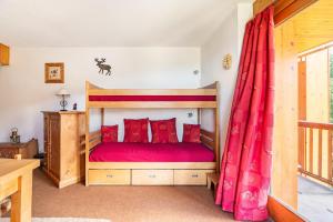 a bedroom with a wooden bed with red pillows at Large Méribel Three Valleys in Les Allues