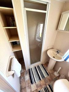 a small bathroom with a shower and a sink at Skegness Seaside Escape in Ingoldmells +9 photos