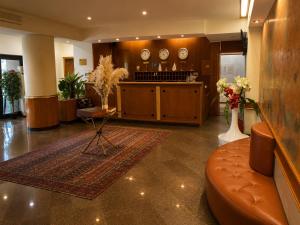 a lobby with a waiting area with clocks on the wall at Marko Polo Hotel in Aksay