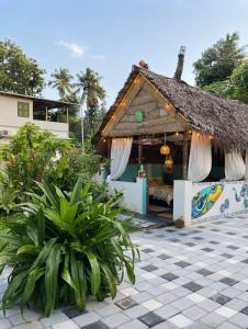 a small house with a thatched roof at VILLA MANTRAA in Varkala