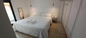 a bedroom with a white bed with two shoes on it at Apartamento Turístico La Miranda in Elche de la Sierra