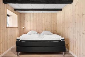 a bedroom with a bed in a wooden wall at 1388-Snedsted-Kaergardsvej-30 in Nørhå