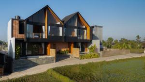 a house with large windows and a lawn at Duality Villas in Ubud