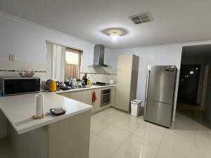 a large kitchen with a stainless steel refrigerator at Sweet Single in Wellard