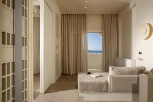 a living room with a chair and a window at Meros, Santikos Collection in Naousa